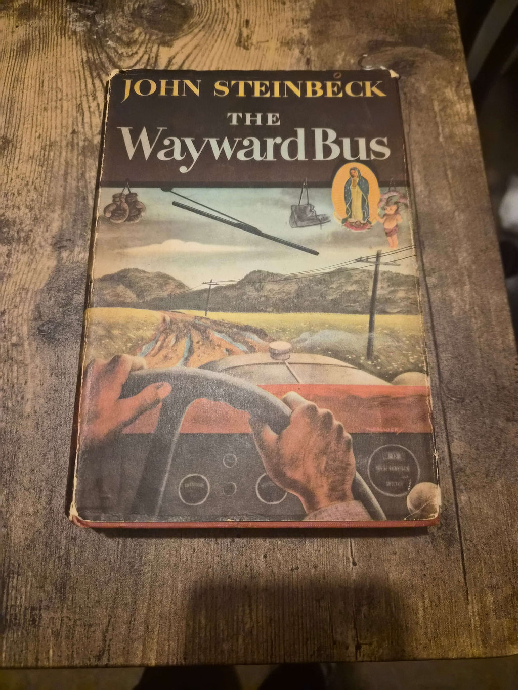 The Wayward Bus 1947 first edition by John Steinbeck with original dust jacket, gripping the steering wheel.