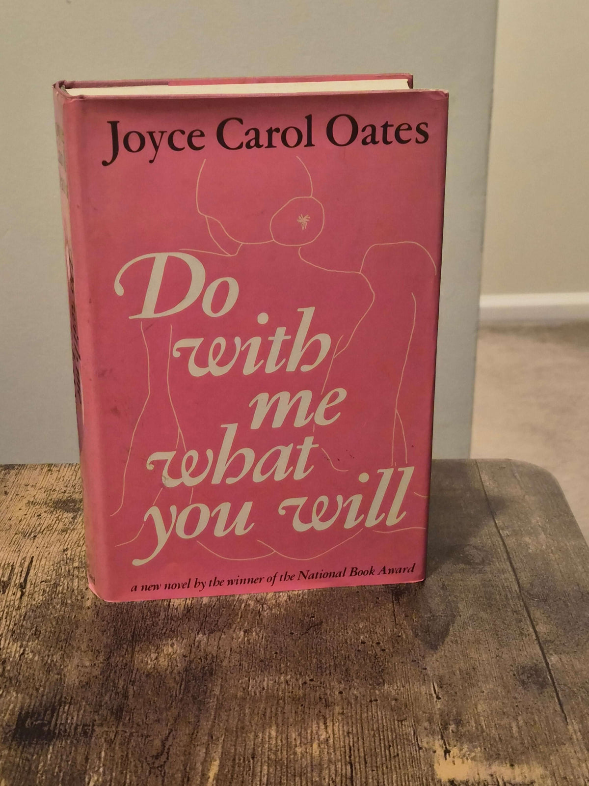 1973 first edition Do With Me What You Will by Joyce Carol Oates on a wooden table.