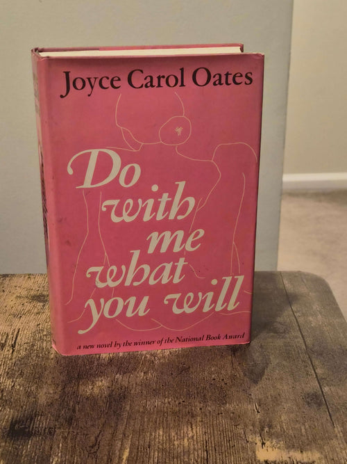 1973 first edition Do With Me What You Will by Joyce Carol Oates on a wooden table.
